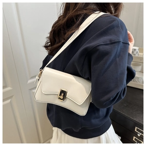 Sac bandoulière chic en cuir beige avec boucle moderne en métal doré et noir élégant