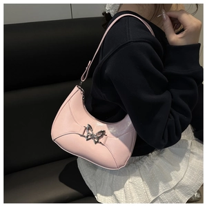 Détail du sac demi-lune rose avec un ornement de papillon en métal argenté sur le devant