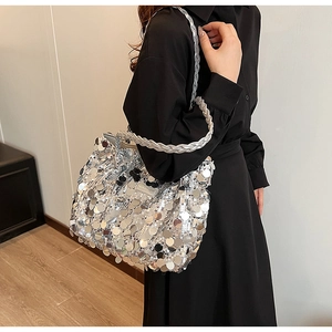 Close-up of a silver sequin tote bag with woven metallic handles and fashion label
