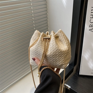 Fashionable beige woven bucket bag with gold chain strap and drawstring closure