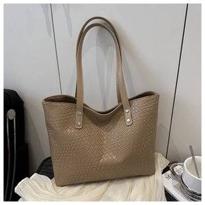 Detail shot of khaki woven texture synthetic leather and silver rivets on tote bag