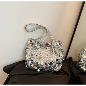 Detail showing shiny silver sequins, woven handle and gold fashion label on tote bag