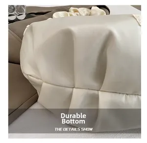 Detail of the wear-resistant bottom with elegant pleated design on a beige shoulder bag