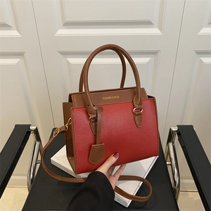 Contrast color red and brown leather tote bag with elegant top handle and gold lettering