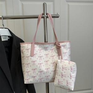 Ensemble cabas tendance avec imprimé nœud rose et pochette assortie sur un présentoir