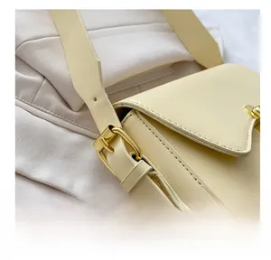 Makro-Detail des beigen Lederriemens mit verstellbarer goldener Schnalle der Handtasche