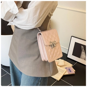 Detail of pink quilted phone bag with silver bow buckle and accordion side structure