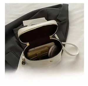 Internal view of a white leather crossbody bag showing capacity for phone and wallet
