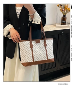 Detailansicht der Vintage-Canvas-Tasche mit Kettenmuster und Ledergriffen am Modell