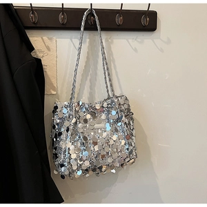 Macro shot of silver sequins on tote bag with woven shoulder strap and fashion label
