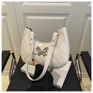 Détail d'un sac à bandoulière blanc en demi-lune avec boucle papillon métallique