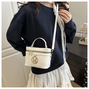 Petit sac boîte en similicuir blanc avec logo M doré porté en bandoulière élégante