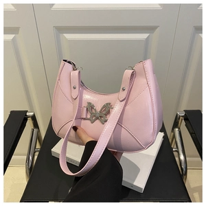 Détail du sac à bandoulière en similicuir rose avec boucle papillon décorative en métal