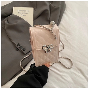 Detail of pink quilted phone bag featuring a silver bow lock and pearl chain strap