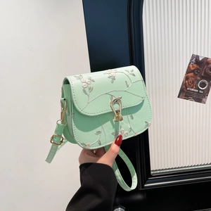 Mint green saddle bag with floral lace embroidery and golden twist-lock closure