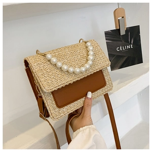 Detail of woven straw and brown leather shoulder bag with large pearl handle chain