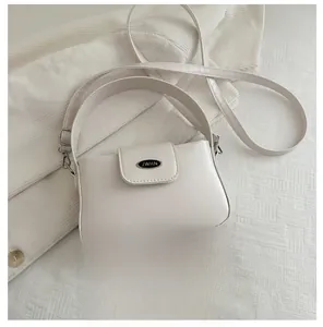 Detail der cremefarbenen Beuteltasche mit silbernem JWHN-Logo und Schultergurt