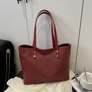 Large woven tote bag in deep burgundy with long shoulder straps and a textured finish
