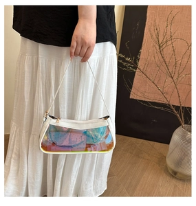 Detailed macro view of holographic transparent baguette bag with white leather piping trim