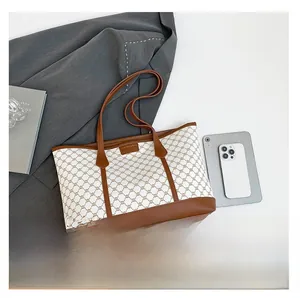 Detail view of large jacquard canvas tote bag with brown leather handles and premium texture