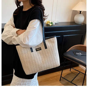 Detail of herringbone woven texture and fashion leather patch on straw tote bag
