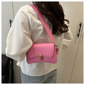 Detail einer rosa Leder-Schultertasche mit goldenem Schloss und breitem Gurt