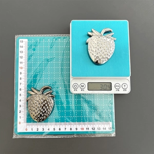 Macro detail of strawberry metal phone stand showing precise size and 30.4g weight