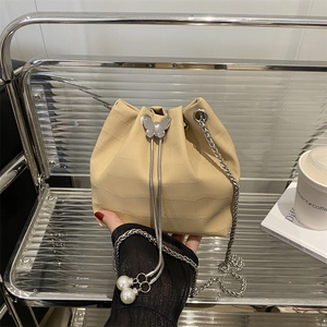 Beige crocodile embossed bucket bag with silver butterfly buckle and pearl tassels