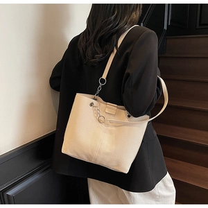 Detail der cremeweißen Shopper-Tasche mit Canvas-Struktur und silberner Metallkette