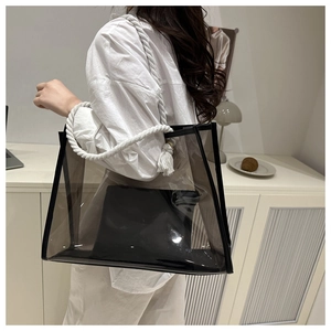 Transparent PVC tote bag with white thick rope handles shown on shoulder by model