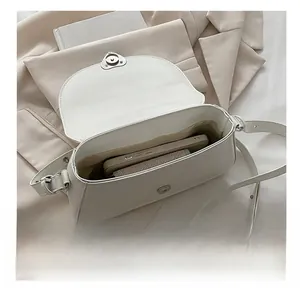 Detail view of the white shoulder bag interior space showing capacity for a smartphone