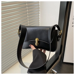 Detail einer minimalistischen schwarzen Kunstledertasche mit eleganter ovaler Gold-Schnalle