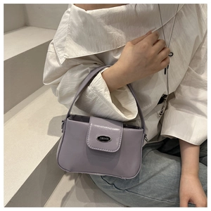 Detailaufnahme der Morandi lila Ledertasche mit ovalem Metallverschluss und JWHN Logo