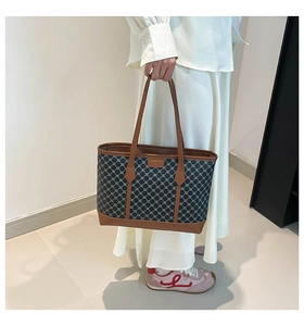 Détail du sac cabas géométrique gris avec poignées en cuir marron et étiquette chic