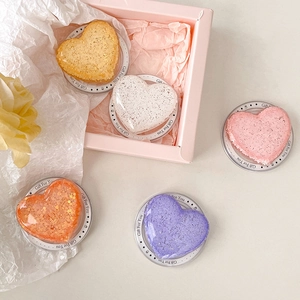 Macro shot of colorful glitter heart-shaped phone grips in a delicate gift box packaging