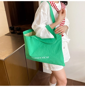 Detail of a bright green large tote bag showing durable fabric and white letter printing