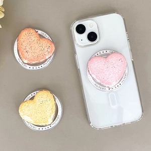 Close-up of heart-shaped glitter phone grips in pink, orange and yellow colors