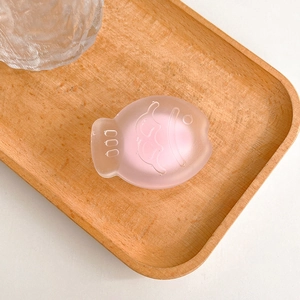 Macro detail of a pink translucent fish-shaped phone grip with a frosted texture