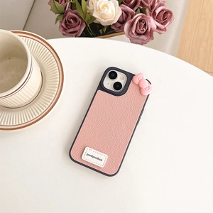 Detailed view of pink lychee grain leather iPhone case with cute bow and brand tag