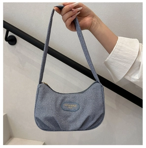 Borsa sottobraccio blu testurizzata con dettagli a pieghe tenuta in mano