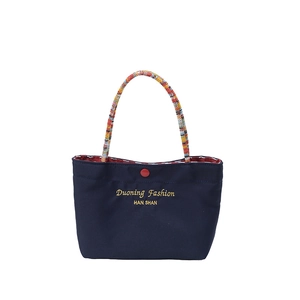 Minimalist navy tote bag with golden lettering and colorful braided rope handles