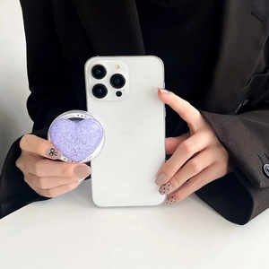 Close-up of purple glitter heart phone grip with Gift For You text on a white phone