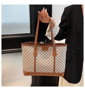 Détail du sac cabas beige vintage avec bordures en cuir marron et motif géométrique