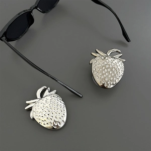 Silver strawberry earrings with textured metal finish on a dark minimalist background