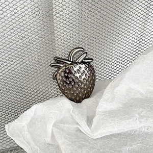 Detailed close-up of a metallic strawberry phone grip featuring a dark silver finish