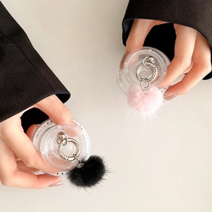 Close-up of fluffy faux fur pompom phone sockets in pink and black with metal rings