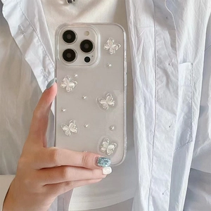 Détail de coque iPhone transparente avec papillons 3D et petites perles déco