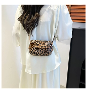 Gros plan d'un petit sac selle à motif léopard porté par un mannequin en studio
