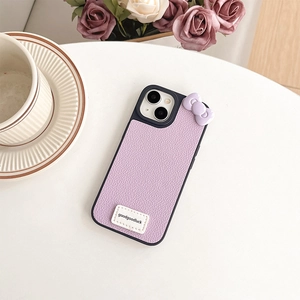 Detail of light purple leather iPhone case with a cute 3D bow and goodluck label