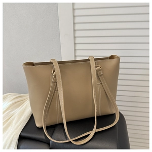 Close-up of khaki tote bag with white contrast stitching and long shoulder straps